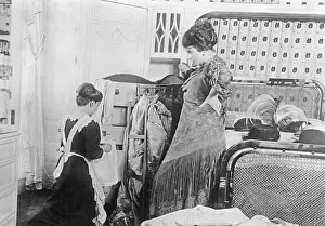 Wardrobe: A maid packs in the suitcase of a lady, 1913
