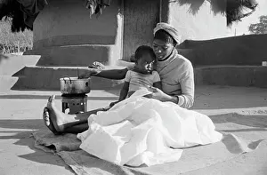 Batik: Making batik patterns on cloth with child on lap