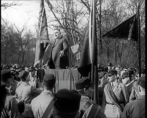 Pendants: Male Civilian Stands on a Platform In Front