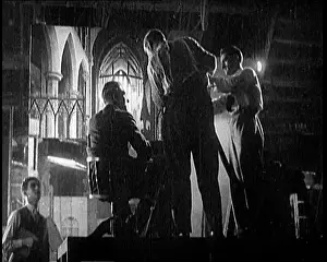 Technicians: Four Male Film Technicians At Work Around A Camera