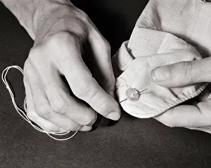 Man S: Male Hand Sewing a Button on Cuff of Shirt
