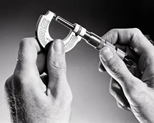 Thickness: Male Hands Holding a Micrometer Gauge