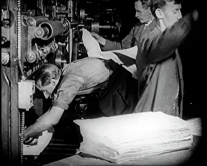Printers: Male Printers Pulling Newspapers Off the Printing Press