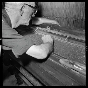 Cowling: A man adjusting the warp ends in the reed of a Jacquard loom