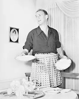 Domestication: Man in an apron setting the table