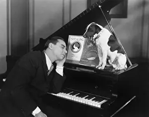 Napping: Man asleep at piano with dog