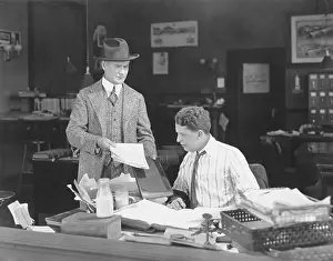 Uncertainty: Man with attitude showing papers to office worker