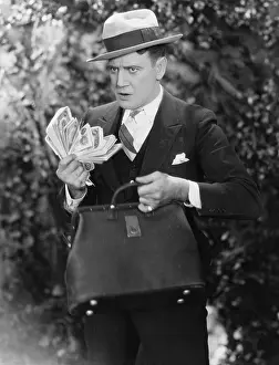 Fedora: Man with bag full of cash
