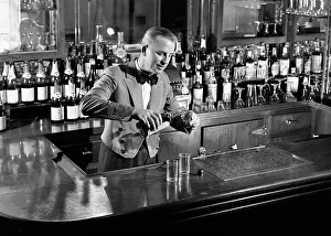 Man Bartender Behind Bar Pouring a Shot Mixing