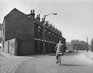 Terraced: Man on bicycle with terrace of houses