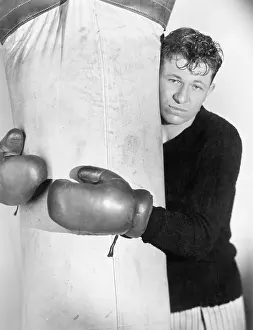 Exhausting: Man in boxing gloves hugging the punching bag