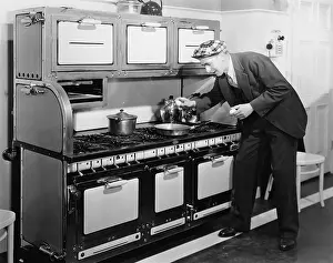 Sustenance: Man breaking egg into a frying pan in the kitchen