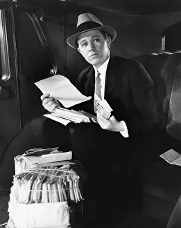 Fedora: Man in car with bundles of mail