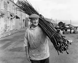 Withies: Man carrying withies for lobster pot making, Devon