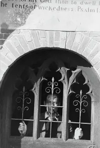 Psalm: Man behind carved grille with biblical quotation above