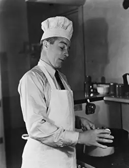 Professionals: Man in chef hat and apron cooking