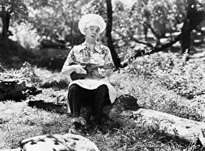 Ukulele: Man in a chefs hat sitting outside and playing the ukulele