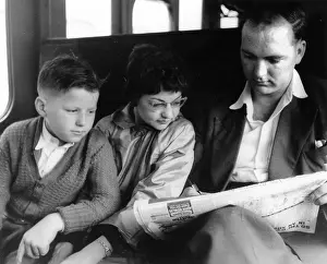 Crossword: Man and two children doing the crossword on a train