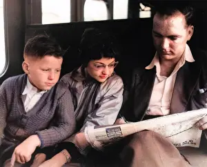 Crossword: Man and two children doing the crossword on a train