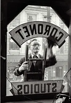 Haymarket: Man cleaning window of Coronet studio