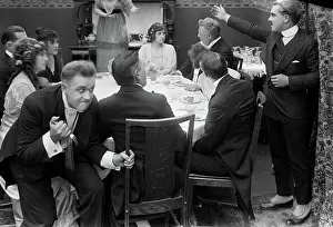 Skulking: Man Clutching Fork Skulking Behind Group at Dinner Tabl