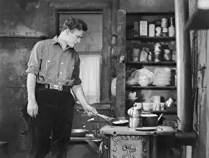 Tend: Man cooking on woodstove