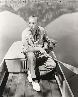 Obedient: A man and his dachshund go rowing