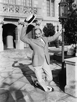 Midadult: Man dancing in the street waving his hat