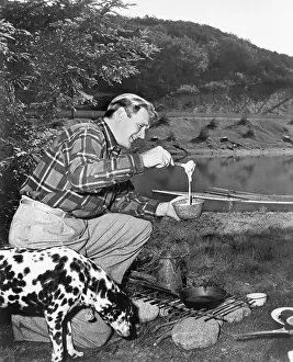 40 45: Man and his dog camping and preparing food