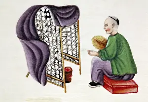 Charcoal: Man drying silkworm cocoons over a charcoal pan