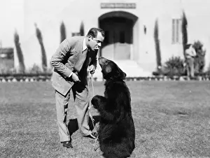 Lightheartedness: Man feeding a bear standing on his lawn