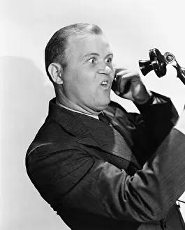 Amazement: Man with funny expression using telephone