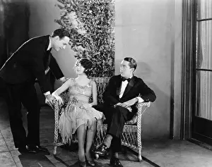 Formalwear: Man greeting a couple sitting on a bench