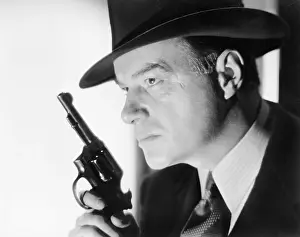 Cocked: A man with a hat and gun