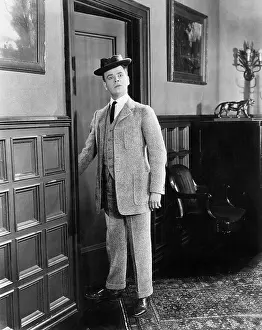 Absurdity: Man with hat looking silly walking into a room