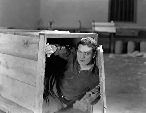 Cautious: Man hiding in wooden crate