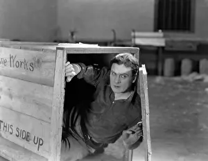 Cautious: Man hiding in wooden crate
