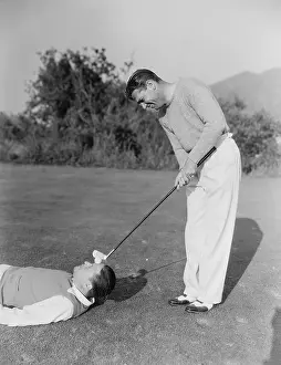 Foreheads: Man hitting golf ball on mans forehead
