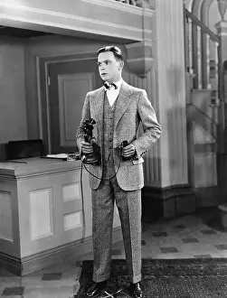 Scarred: Man holding a candlestick phone and looking away