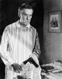 Harmful: Man holding a handgun in a handkerchief looking distraught