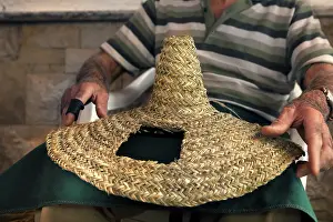 Fibres: Man holding a traditional woven hat made from
