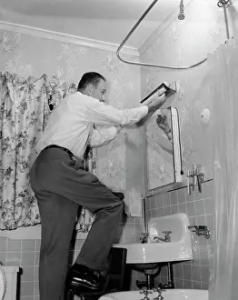 Fixture: Man on Home Repair Step Stool in Bathroom Replacing