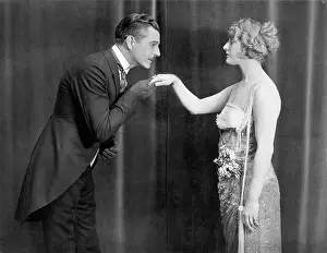 Suitor: Man kissing womans hand