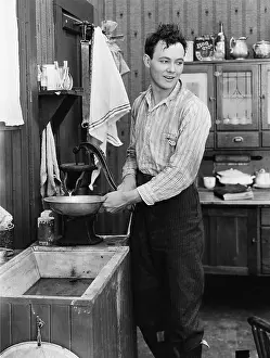 Washbasin: Man in a kitchen pumping water
