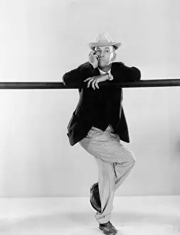 Headshots: Man leaning against a balance beam with his legs crossed