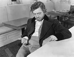 Ruffled: Man leaning against a counter in a restaurant with