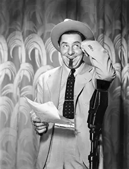 Everett Collection (old Visuals): Man leaning on a microphone looking into the air