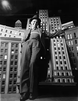 Proportion: Man leaning against model buildings