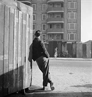 Enclosing: Man leaning on street corner