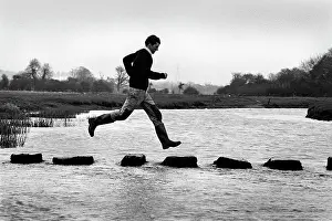 Bounding: A man leaps along the stepping stones at Ogmore Castle